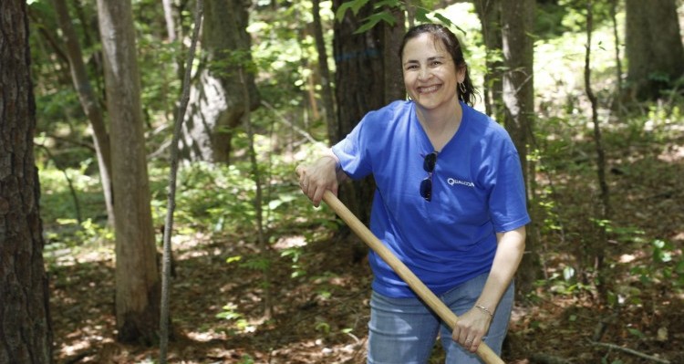 Woman with Rake in Forest - Give to Triangle Land Conservancy