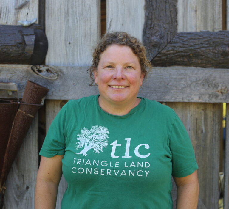 Leigh Ann Hammerbacher smiling in from of a wood barn.