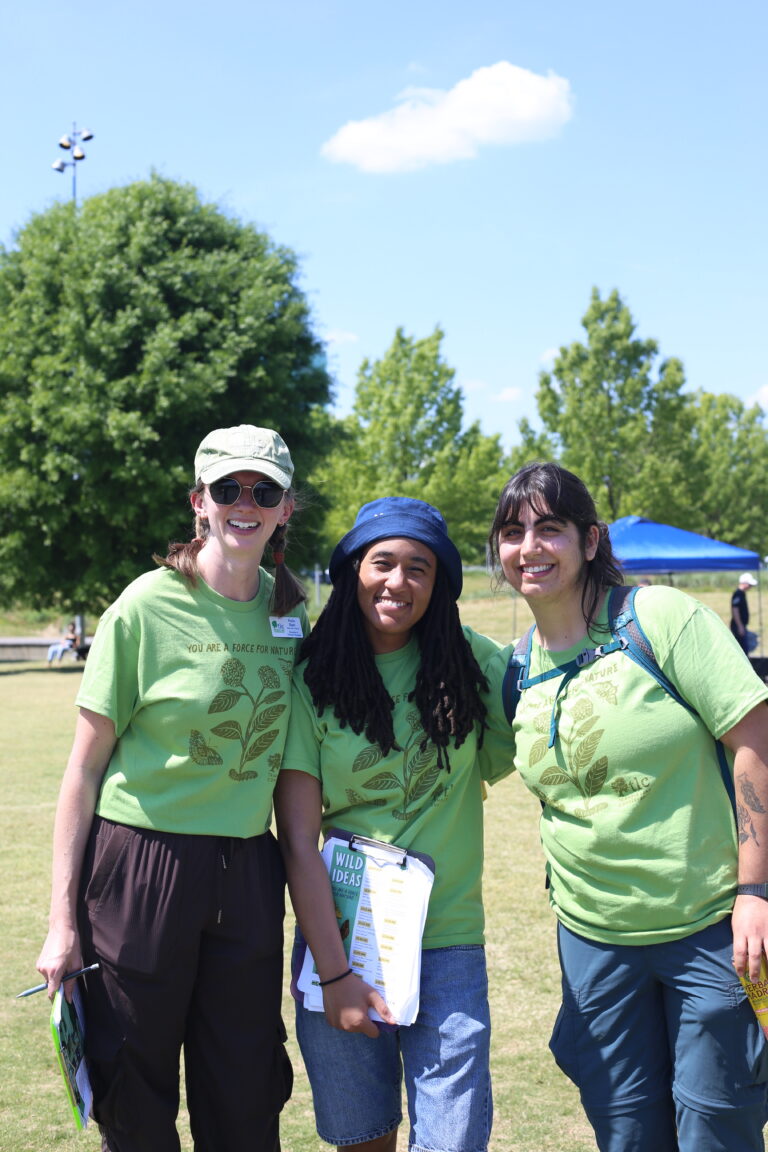 TLC's Education and Outreach team, Kayla Ebert, Amaya Horner, and Meera Butalia, smile for a photo at Wild Ideas.