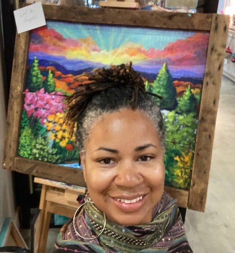 Ayanna Smith smiling in front of a painted landscape.
